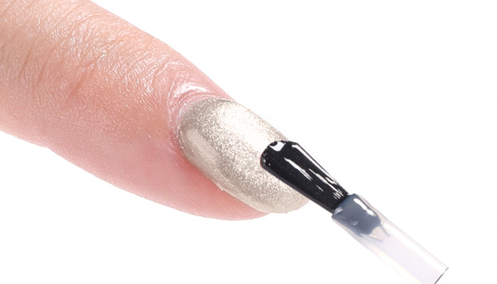 Applying glossy top gel coat to seal gel manicure with glass-like shine