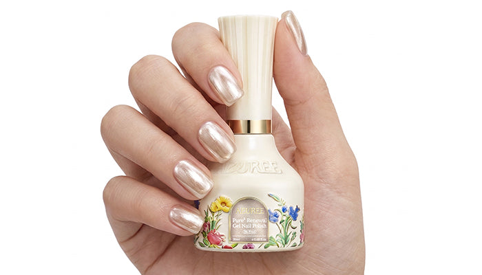 Close-up of pearl cat-eye gel nail polish bottle with glossy metallic manicure